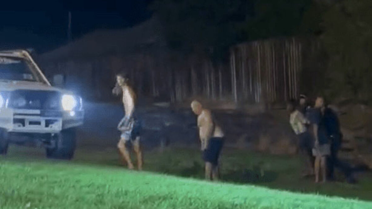 Three men and a 14-year-old girl outside at night, with police presence and car headlights in the background.