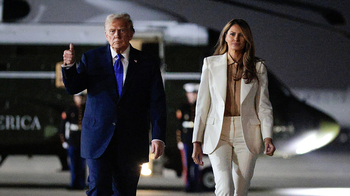 Donald Trump and Melania walking near a helicopter, with focus on Trumpu2019s body language and finger-pointing gesture.
