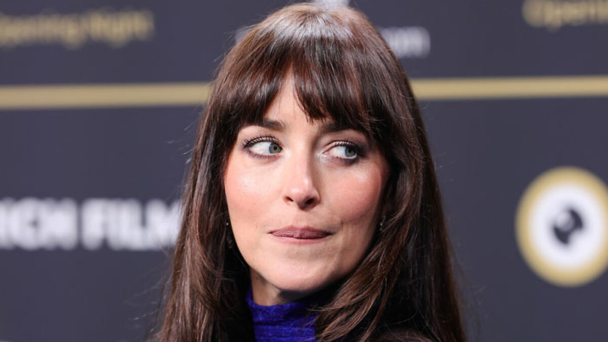 Close-up of Dakota Johnson with natural makeup and dark hair wearing a sheer Gucci dress at Zurich Film Festival.