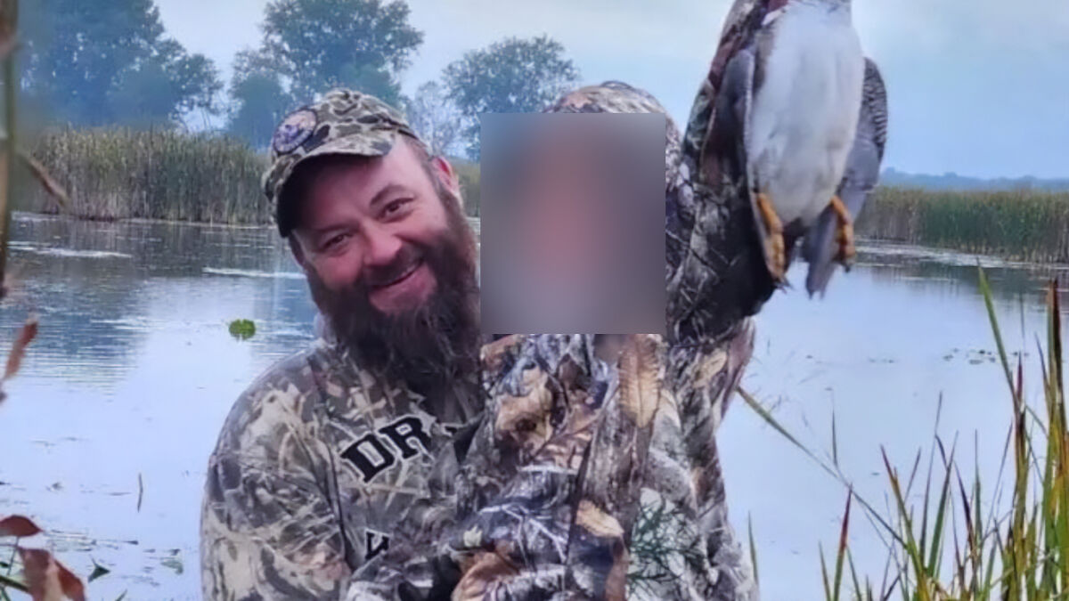 Bearded man in camouflage gear holding a bird near a wetland, linked to Michigan church tragedy and Charlie Kirk attack.