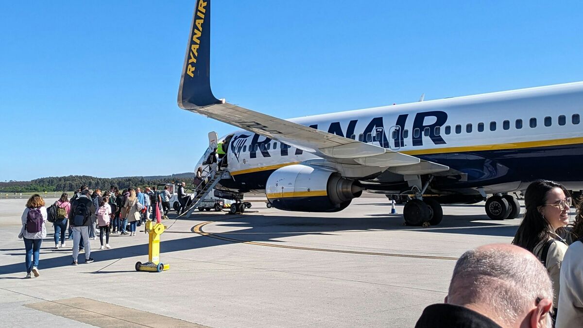 Passengers boarding a Ryanair plane on the tarmac under clear blue skies before a chaotic flight incident.