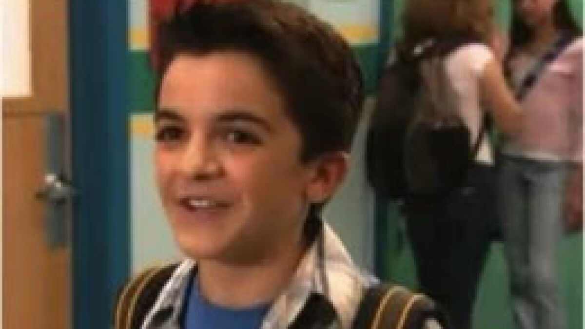 Young Nickelodeon actor smiling in a school hallway scene, related to homeless actor fundraiser and street-side makeover.