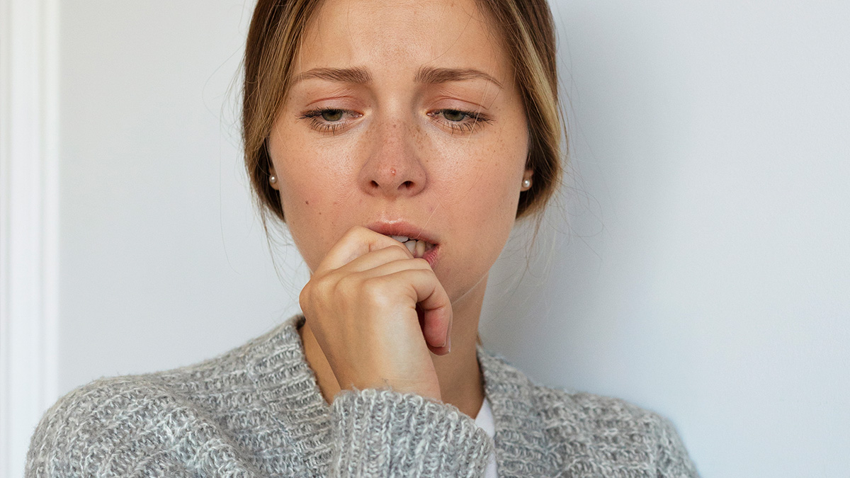 Worried woman biting nails, representing the anxiety and fear from creepiest customer encounters situations.