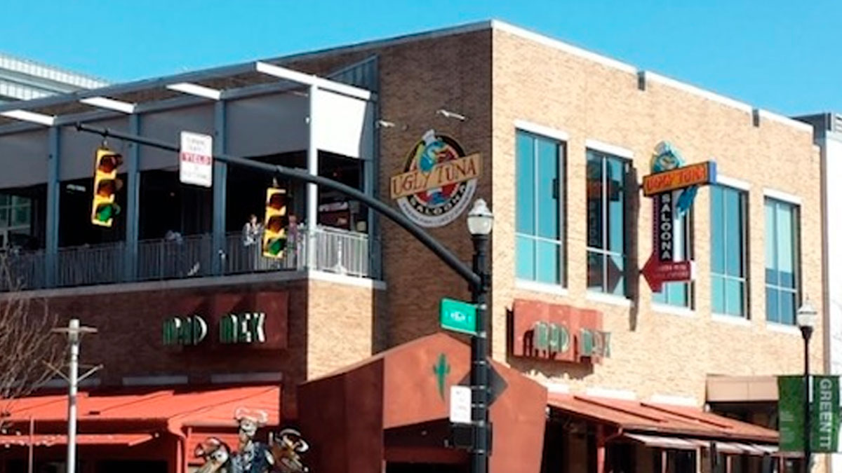 Urban street view of a building with restaurants and traffic lights, capturing a popular disappearance cases location.