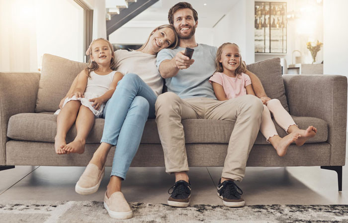 Family cuddling on couch with dad and daughters, showing a warm and affectionate family moment at home. Family cuddling on couch with dad and daughters, showing a warm and affectionate family moment at home.