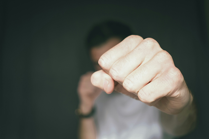 Close-up of a young student raising a fist aggressively, symbolizing a shocking classroom incident involving a teacher and suspension. Close-up of a young student raising a fist aggressively, symbolizing a shocking classroom incident involving a teacher and suspension.