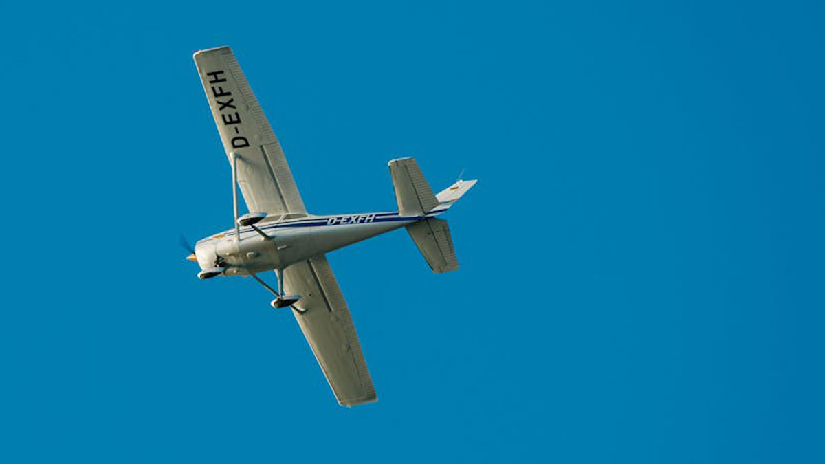 Small single-engine airplane flying against a clear blue sky, illustrating terrifying moments people thought were their last luck.