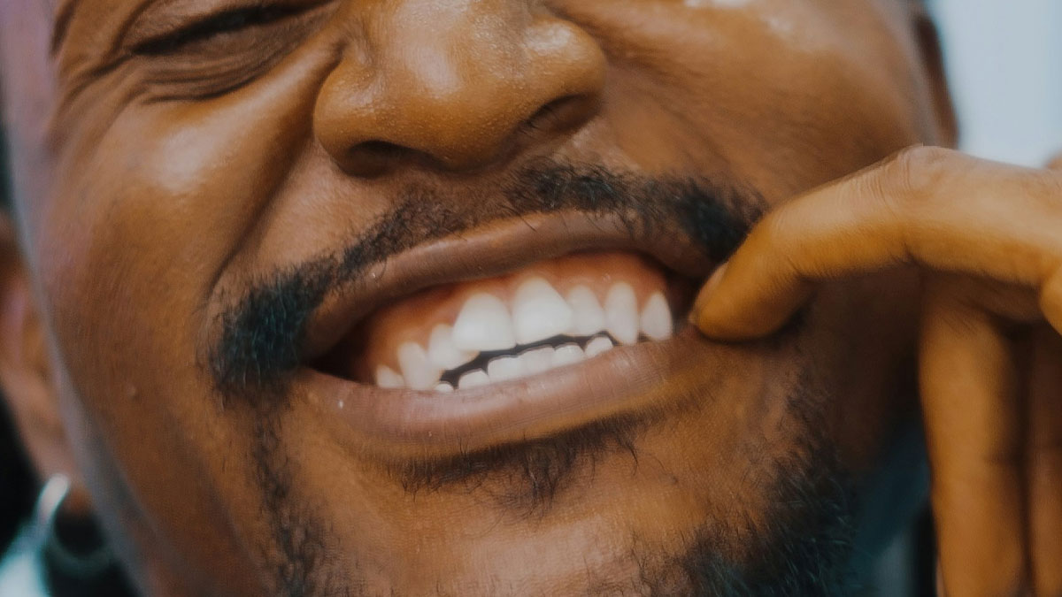 Close-up of a manu2019s mouth showing teeth and facial hair highlighting issues with bad hygiene causing gagging.