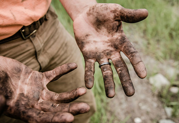 Close-up of dirty hands covered in grime, highlighting poor hygiene that could cause partner discomfort and gagging.