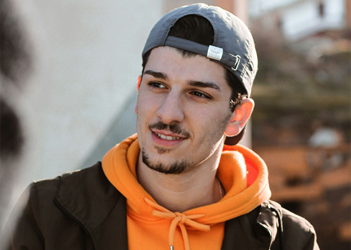 Young landlord wearing a backward cap and orange hoodie, looking confident after getting rid of horrible tenants. Young landlord wearing a backward cap and orange hoodie, looking confident after getting rid of horrible tenants.