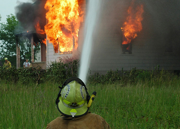 Firefighter spraying water on a burning house as landlord finally gets rid of horrible tenants with a chance for revenge. Firefighter spraying water on a burning house as landlord finally gets rid of horrible tenants with a chance for revenge.