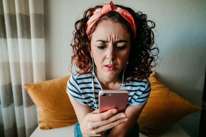 Woman with headband looking at phone with concern, depicting emotions related to dog shelter and police involvement. Woman with headband looking at phone with concern, depicting emotions related to dog shelter and police involvement.