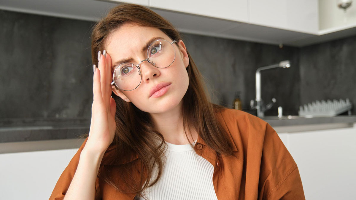 Frustrated woman with glasses holding her head, reflecting tension over dream truck and unpaid money disputes.