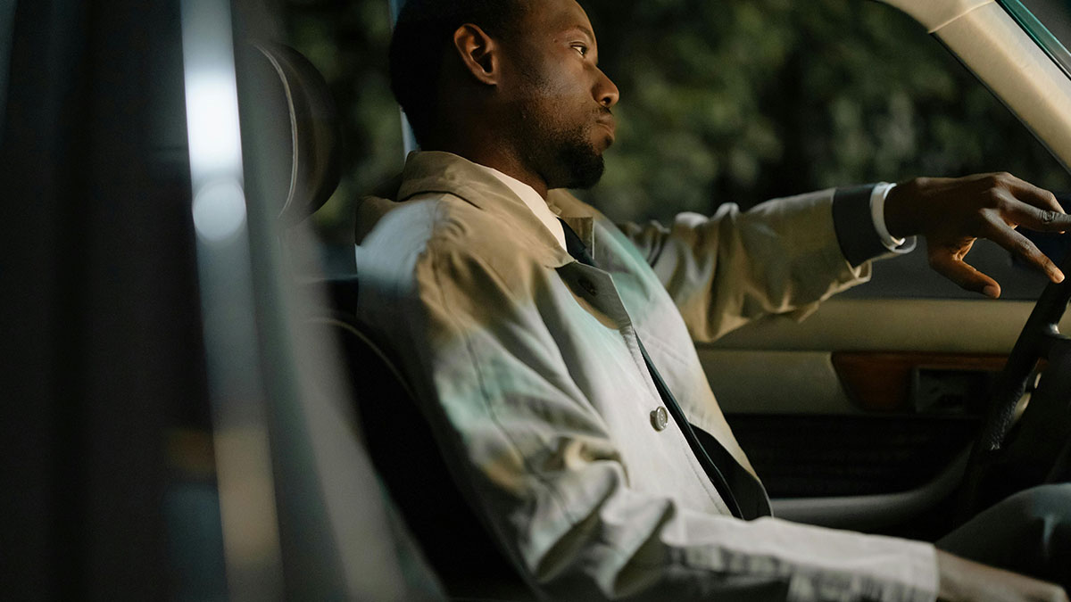 Man sitting in car looking upset, illustrating entitled lady manipulating boyfriend to break up and demand free rides.