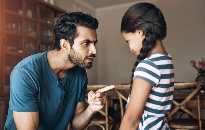 Man in blue shirt angrily pointing finger at young girl with braided hair, illustrating rude hubby behavior scenario. Man in blue shirt angrily pointing finger at young girl with braided hair, illustrating rude hubby behavior scenario.