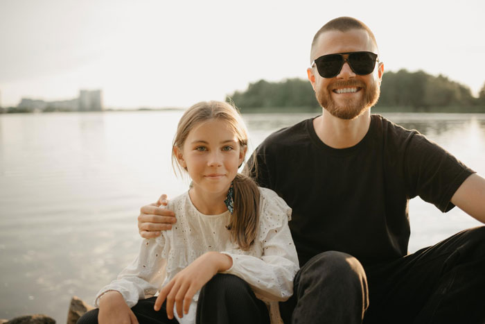 Father and 10-year-old daughter sitting by the lake, highlighting child support and parental control issues. Father and 10-year-old daughter sitting by the lake, highlighting child support and parental control issues.