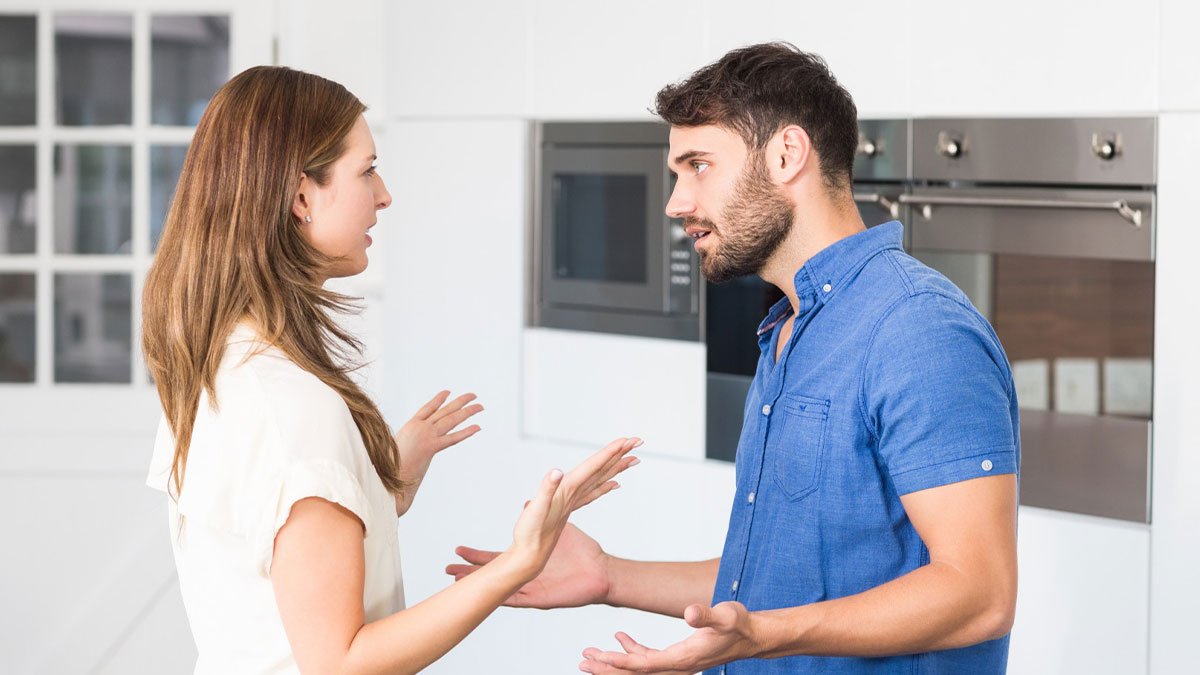 Couple arguing in modern kitchen over house ownership, highlighting conflict about 50/50 property partnership demands.