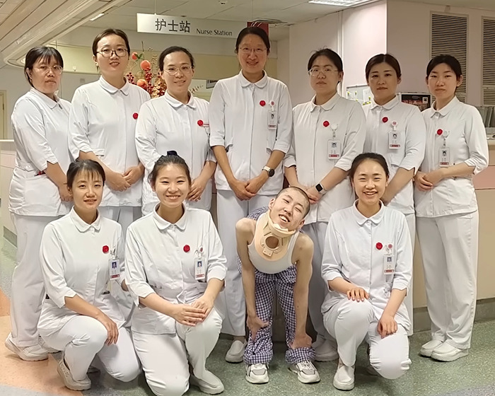 Medical staff posing with a boy bent at 180 degrees who is now standing up straight after long-term treatment. Medical staff posing with a boy bent at 180 degrees who is now standing up straight after long-term treatment.