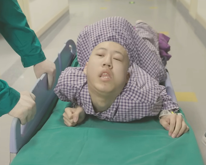 Young boy with rare condition bent at 180 degrees lying on hospital bed receiving medical care Young boy with rare condition bent at 180 degrees lying on hospital bed receiving medical care