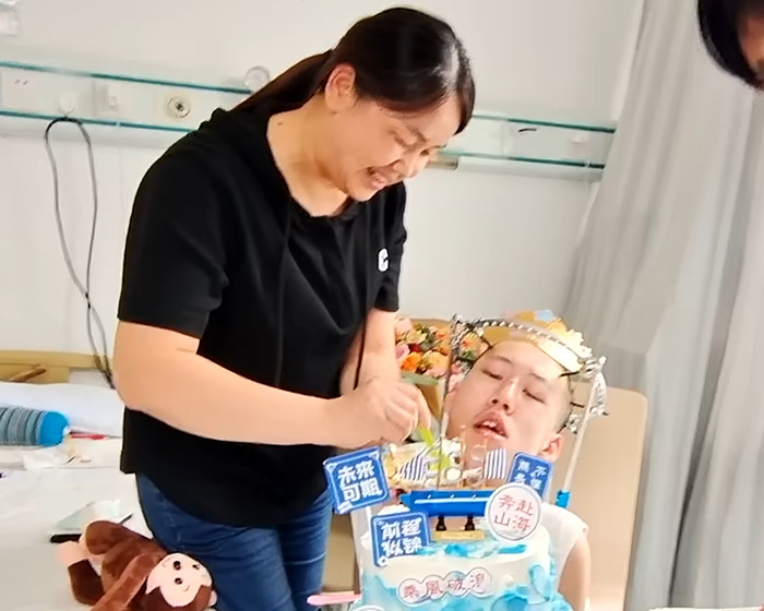 Caregiver feeding folded boy bent at 180 degrees who is finally able to stand up straight after long-term treatment. Caregiver feeding folded boy bent at 180 degrees who is finally able to stand up straight after long-term treatment.