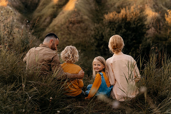 Family sitting outdoors in tall grass, capturing a moment amid tension from a stalker half-sis airing dirty laundry online. Family sitting outdoors in tall grass, capturing a moment amid tension from a stalker half-sis airing dirty laundry online.
