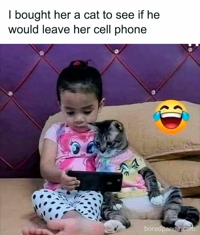 Child and cat wearing matching outfits sitting together, using a phone, showcasing cute cat memes and adorable cat moments.