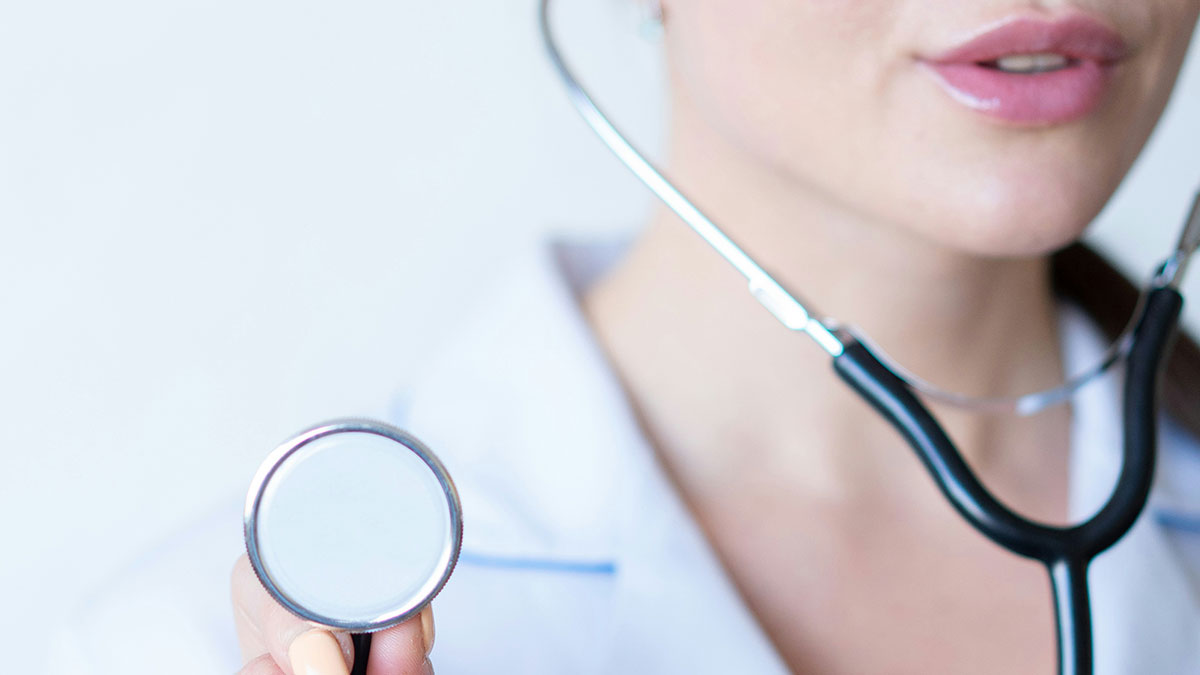Close-up of a paramedic holding a stethoscope focused on emergency medical technician tools and care.