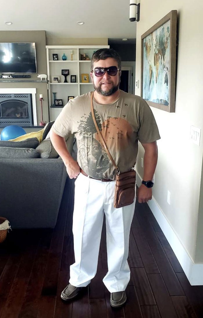 Man with sunglasses wearing casual clothes and a small purse standing indoors, showing funny parents style.