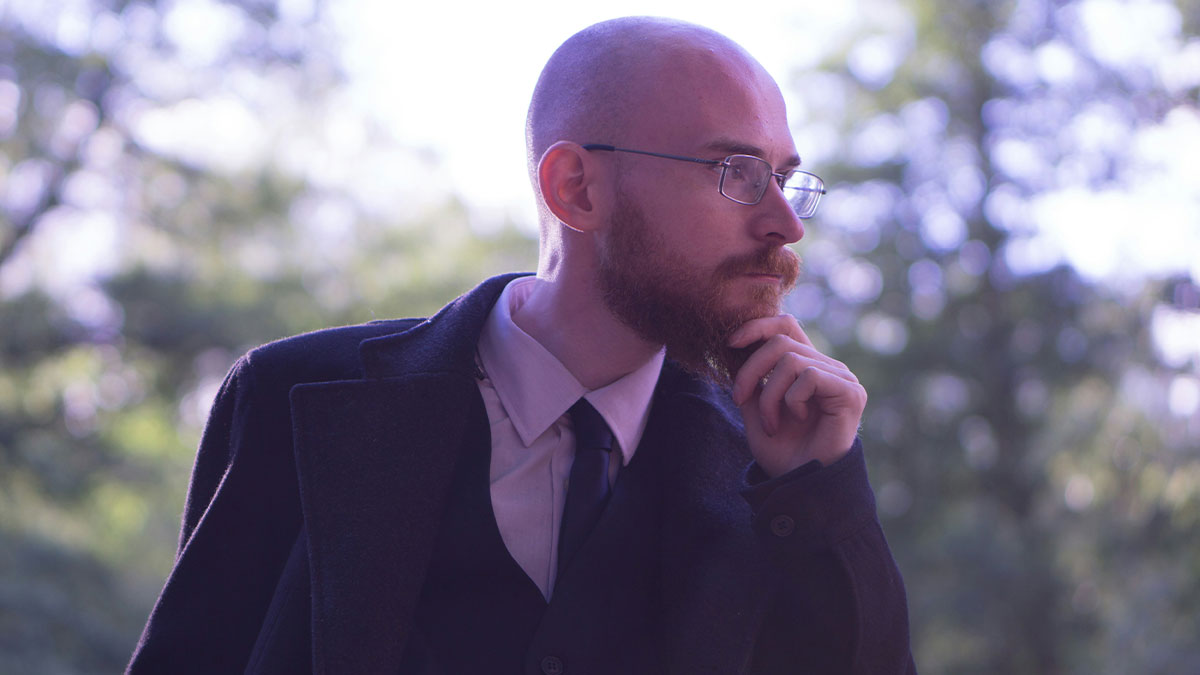 Bald professor with glasses and beard thoughtfully posing outdoors, representing professors who left an impression on students.