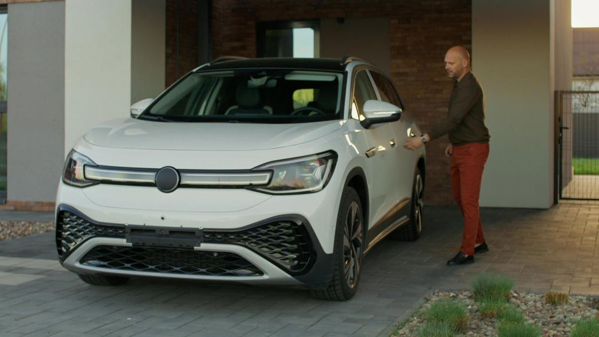 Man inspecting white car in driveway, relating to man towing entitled neighbor's car for blocking his vehicle.
