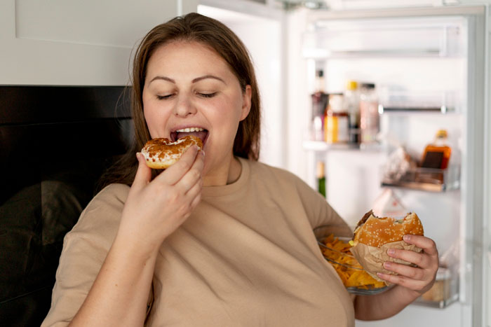 Woman eating food from fridge, representing drama over bro’s girlfriend frequently coming and eating family food. Woman eating food from fridge, representing drama over bro’s girlfriend frequently coming and eating family food.