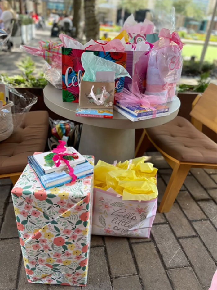 Table with colorful gift bags and wrapped presents at a grandma baby shower celebrating her new status outdoors. Table with colorful gift bags and wrapped presents at a grandma baby shower celebrating her new status outdoors.