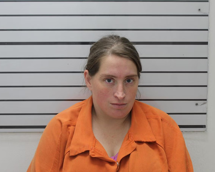 Woman in an orange prison uniform posing for a mugshot after arrest related to stepfather and 11-year-old girl case Woman in an orange prison uniform posing for a mugshot after arrest related to stepfather and 11-year-old girl case