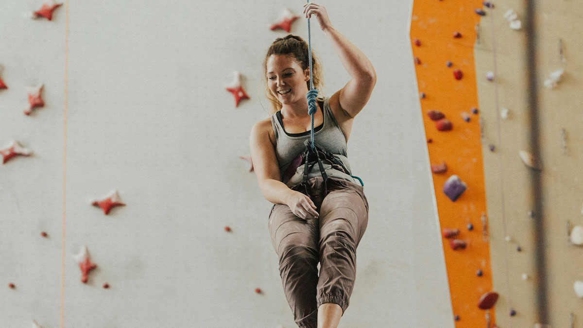 Woman enjoying indoor climbing, symbolizing feelings after guy considers her his girlfriend after one date anniversary gift misunderstanding