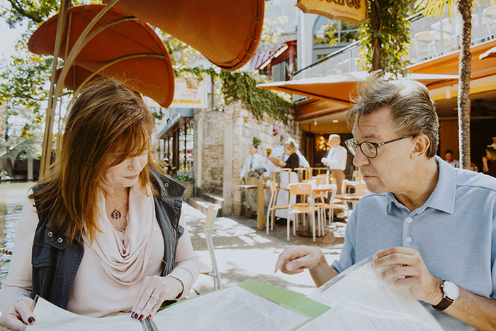 Middle-aged man and woman discussing documents outdoors, reflecting strained stepdad and stepkids inheritance conflict. Middle-aged man and woman discussing documents outdoors, reflecting strained stepdad and stepkids inheritance conflict.