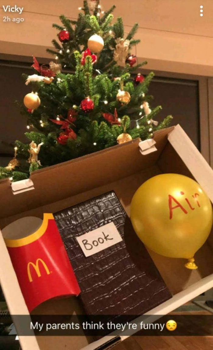 Holiday gift box with a McDonald's fries container, a book labeled "Book," and a balloon labeled "Air" by funny parents.