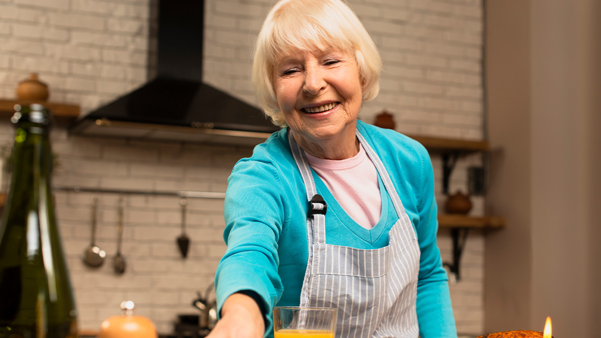 Elderly woman in apron smiling in kitchen, illustrating a woman going no-contact after allergy risk with her MIL.