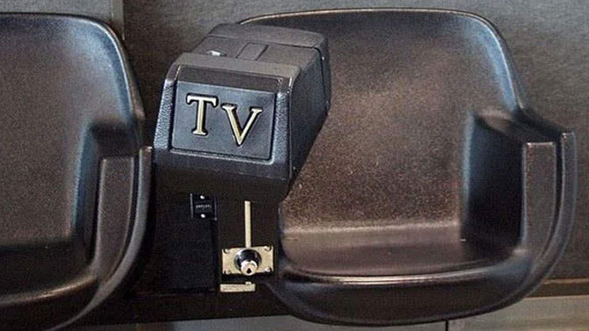 Old black plastic TV antenna switch between two vintage armchairs, evoking nostalgic memories of old age.