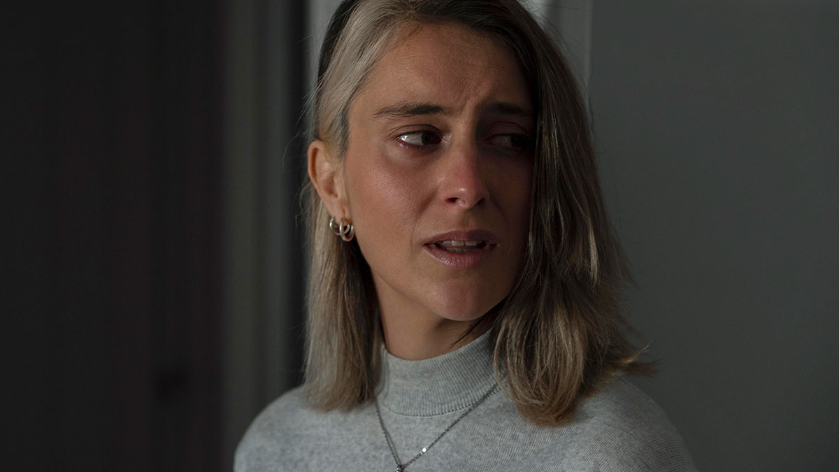 Woman with light brown hair looking distressed in a dimly lit room reflecting emotions of man hating how easy everything comes to wife