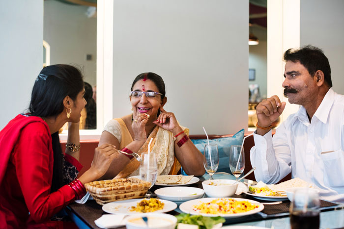 A husband and parents joyfully sharing a meal and conversation in a cozy dining setting. A husband and parents joyfully sharing a meal and conversation in a cozy dining setting.