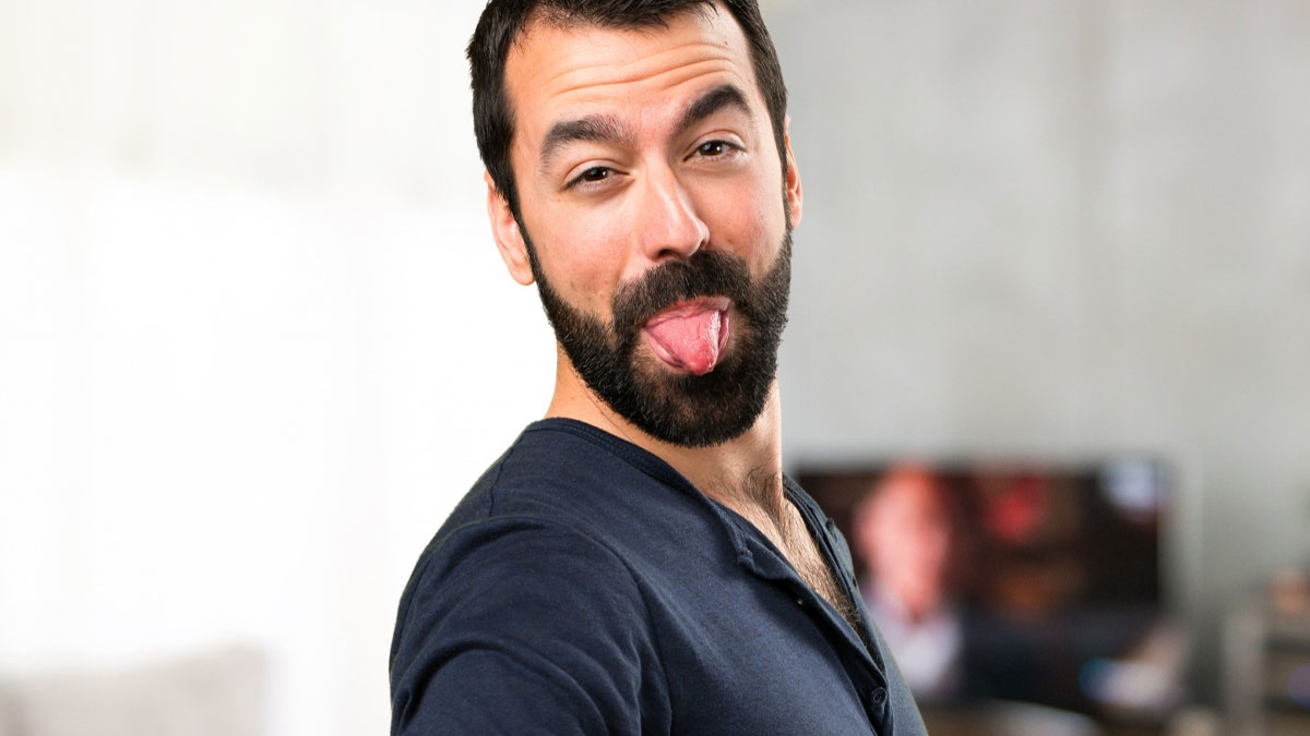 Man making a funny face by sticking out his tongue, illustrating reasons women get the ick from a guy.