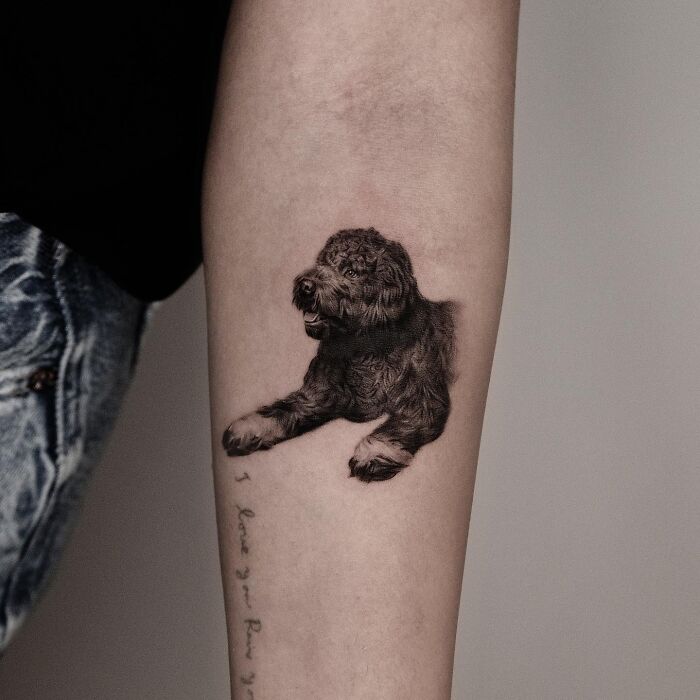 Realistic dog pet tattoo on forearm by Korean tattoo artist known for emotional pet tattoos.