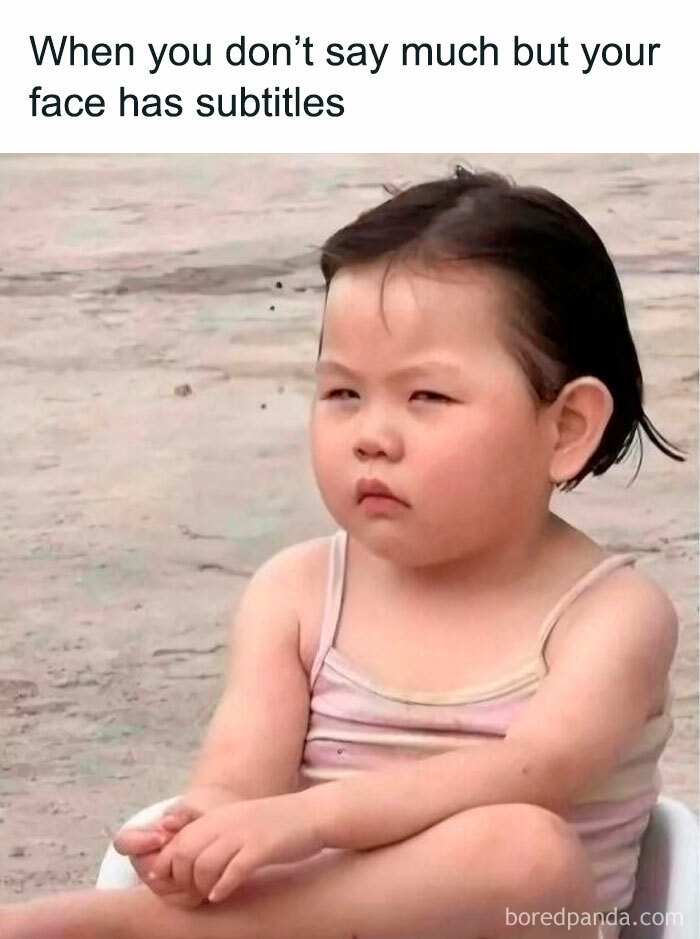 Young child sitting with a serious expression, capturing the mood of introvert memes after socializing.