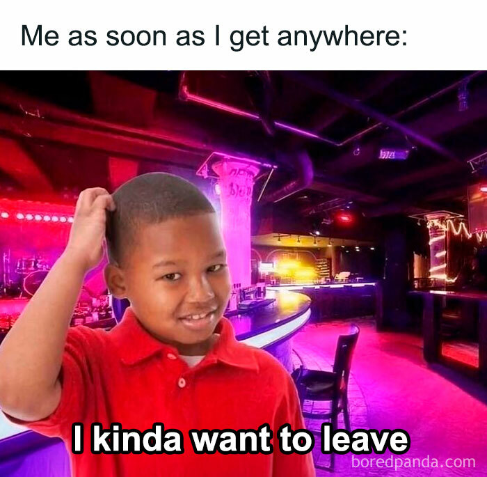 Young boy in a red shirt in a neon-lit bar, expressing introvert feelings of wanting to leave after socializing.