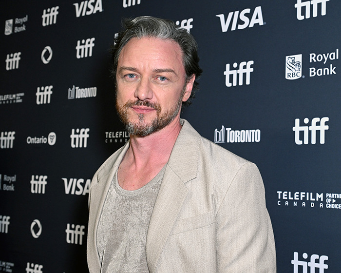 James McAvoy posing at Toronto Film Festival event, looking at camera in beige jacket and gray shirt. James McAvoy posing at Toronto Film Festival event, looking at camera in beige jacket and gray shirt.