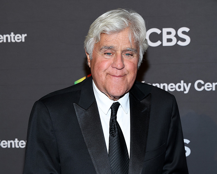 Jay Leno wearing a black suit and tie, posing at a media event, reacting to Jimmy Kimmel suspension comments. Jay Leno wearing a black suit and tie, posing at a media event, reacting to Jimmy Kimmel suspension comments.