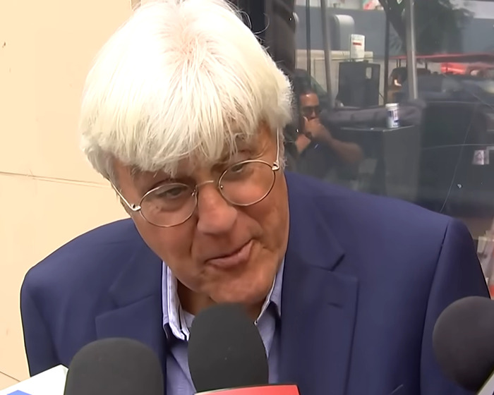 Jay Leno speaking to reporters wearing glasses and a blue suit jacket reacting to Jimmy Kimmel's suspension comments. Jay Leno speaking to reporters wearing glasses and a blue suit jacket reacting to Jimmy Kimmel's suspension comments.