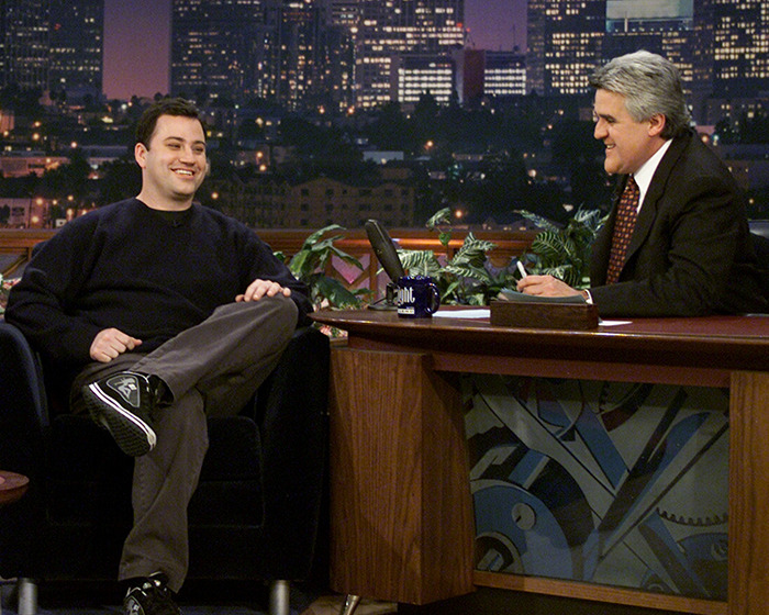 Jay Leno hosting a late-night talk show, engaging in conversation with a seated guest in a studio setting. Jay Leno hosting a late-night talk show, engaging in conversation with a seated guest in a studio setting.