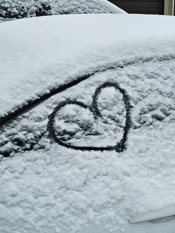 Heart shape drawn on car window covered with snow, illustrating things women are not allowed to do that men can do freely.