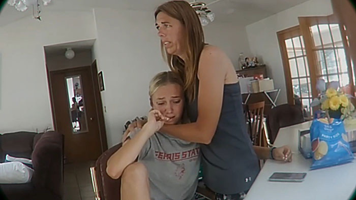 Woman comforting crying daughter in a kitchen setting as prosecutor discusses mom secretly tormenting daughter over time Woman comforting crying daughter in a kitchen setting as prosecutor discusses mom secretly tormenting daughter over time